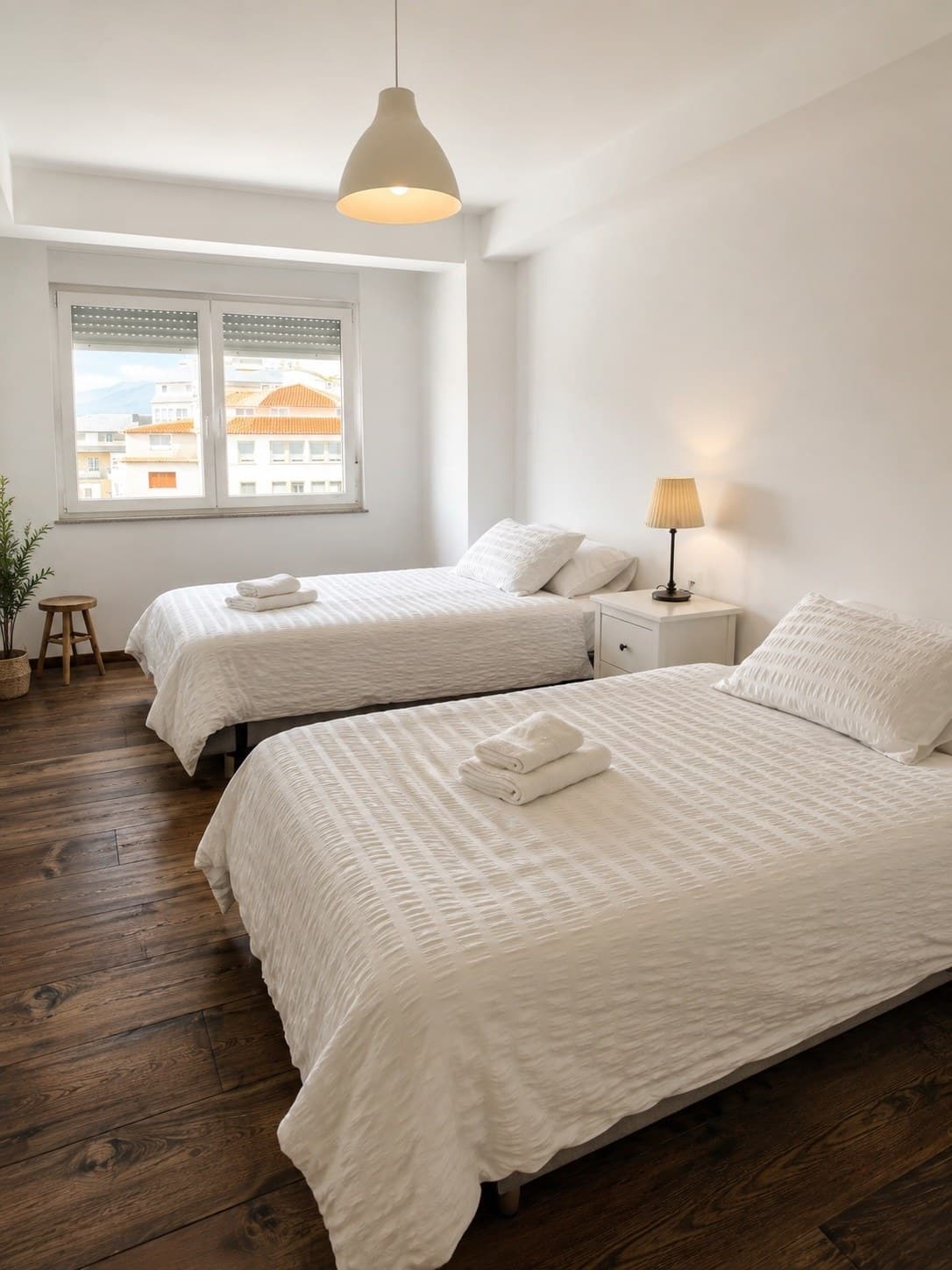 Habitación con dos camas individuales, suelos de madera cálidos y ventana al exterior